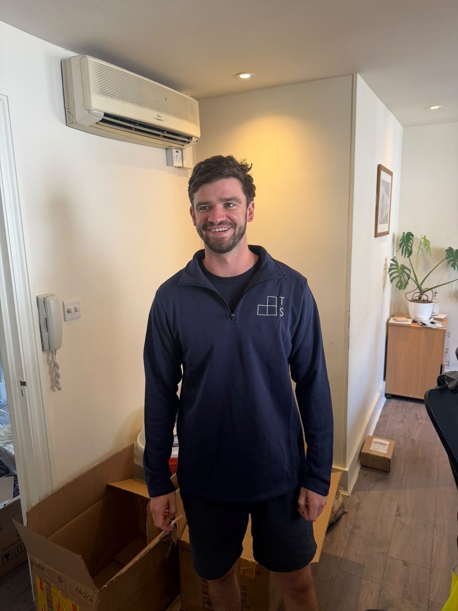 A Thornhill Shann team member wearing a navy quarter-zip with the TS mark on the chest